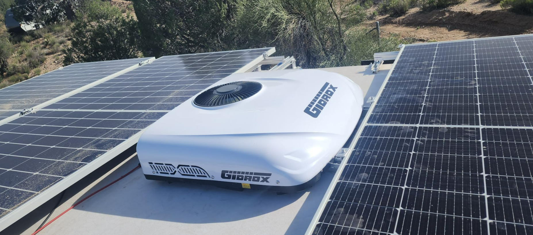 Gidrox 12V DC RV air conditioner installed between rooftop solar panels